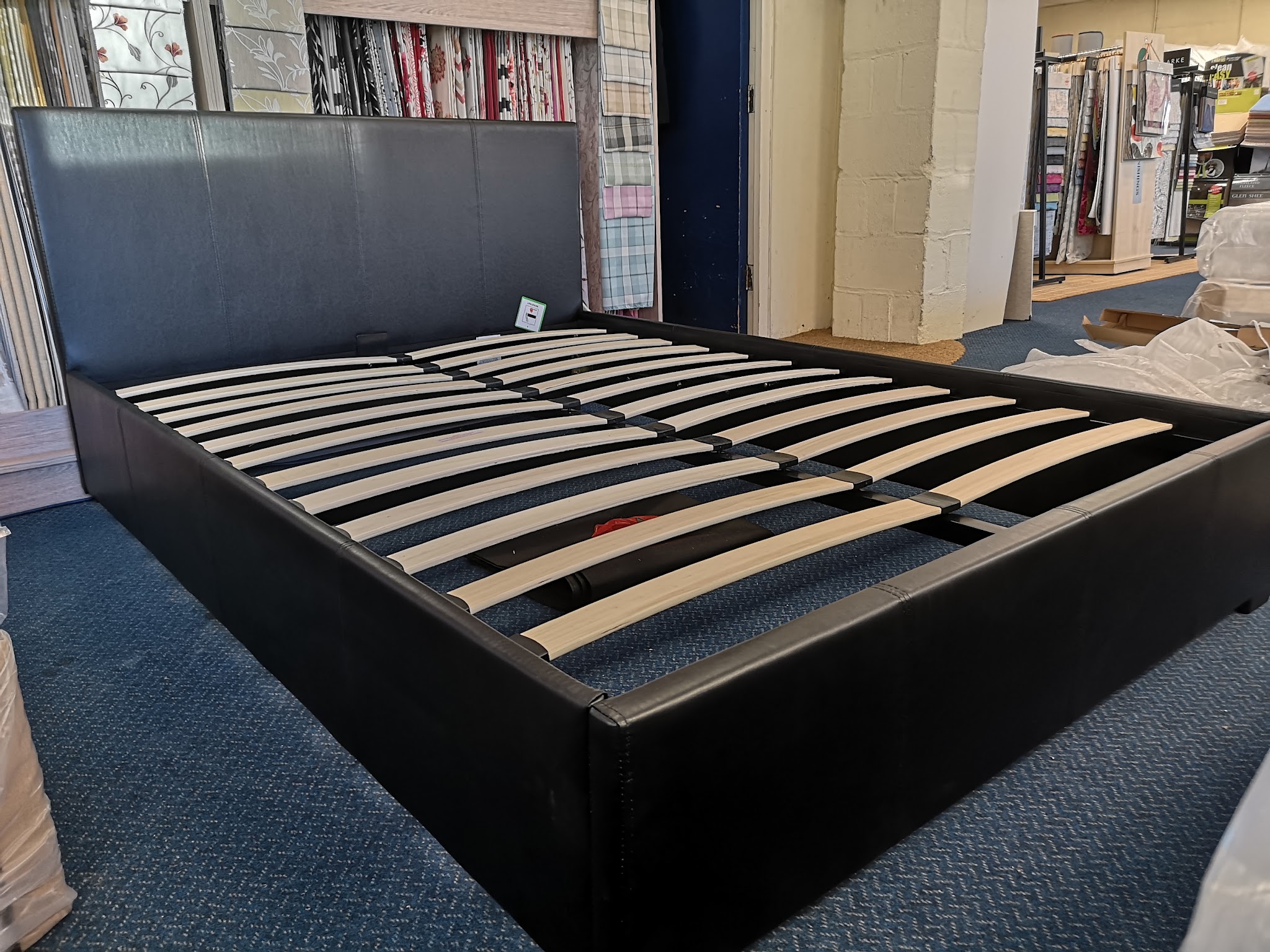 Black faux-leather bed frame on the shop floor